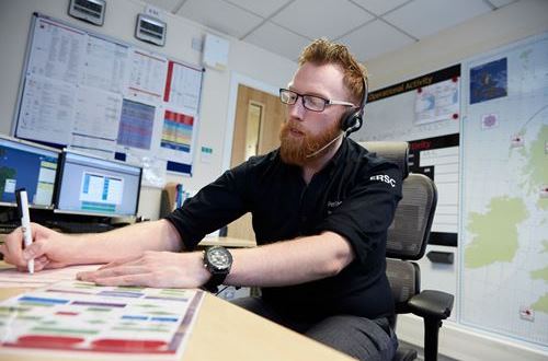 Mark wearing a headset and sitting at desk